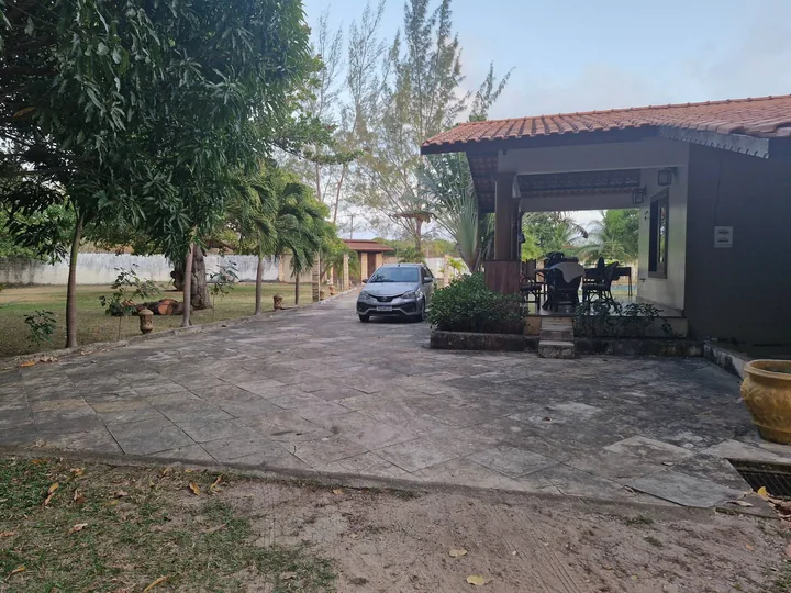 Pátio calçado e acesso à garagem ao lado da casa.